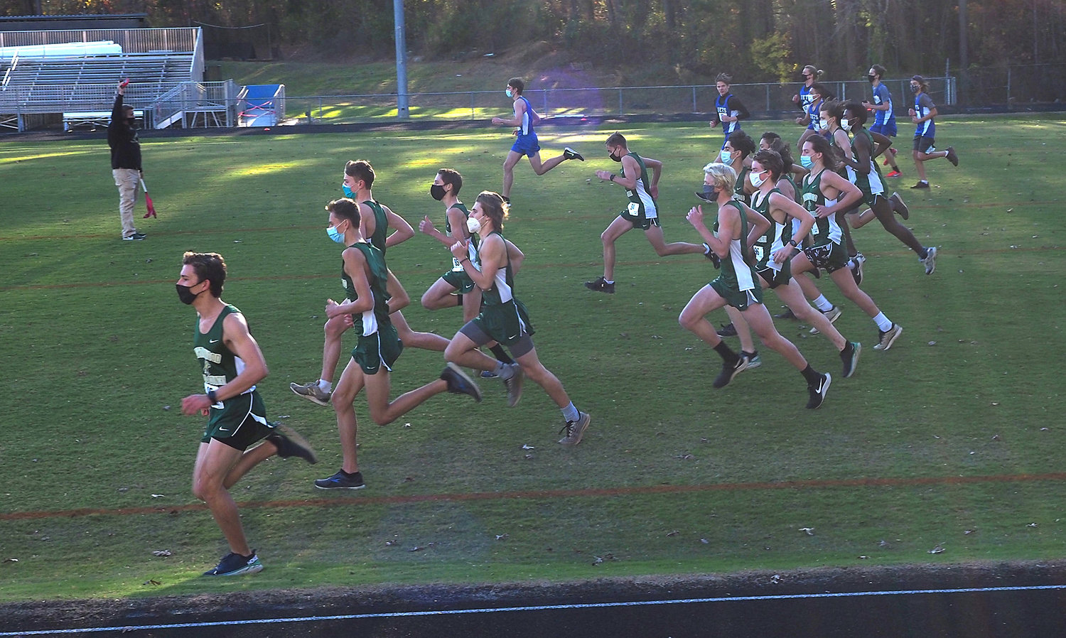 Northwood and Jordan-Matthews men's runners take off at a non-conference cross country meet on Nov. 24 at Northwood High School. Runners wore masks at the start of the race and took them off once they were distanced from others on the course.